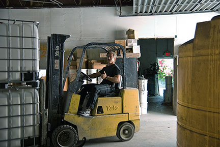 Forklift moving roof coating materials in The Roof Store factory warehouse — Davie, Florida