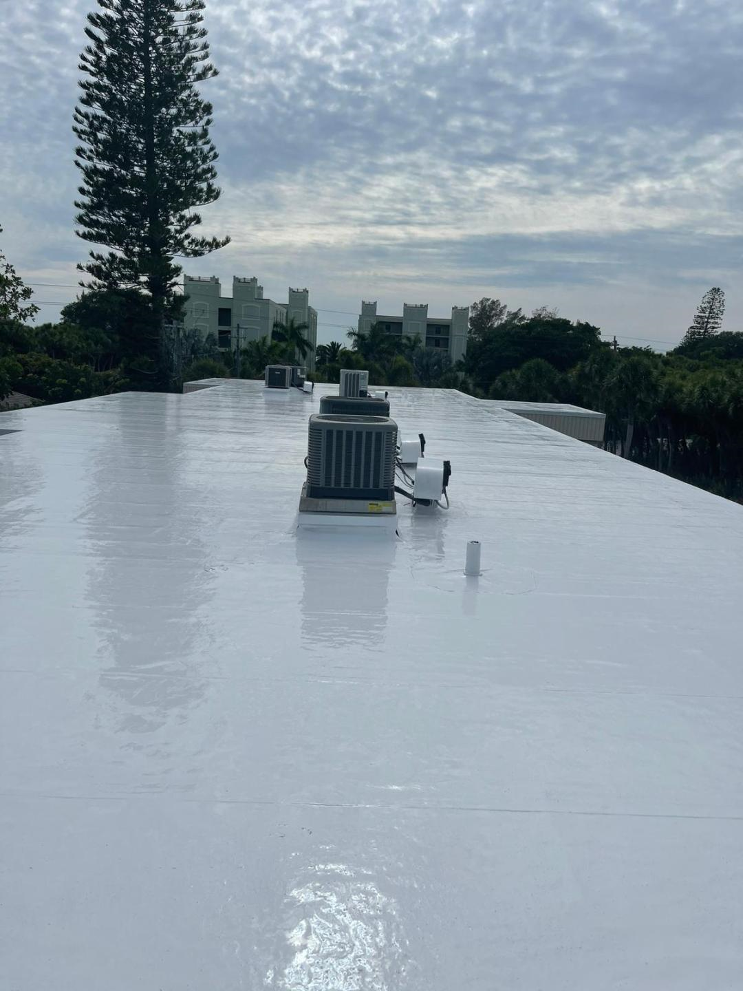 Completed white elastomeric flat roof coating with HVAC units